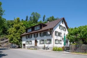 une maison blanche avec un toit marron dans l'établissement Gasthof Löwen Tosters, à Feldkirch