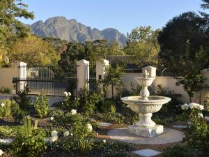 Una fuente en un jardín con montañas al fondo. en The Protea Apartment no01, en Franschhoek