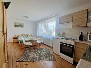 a kitchen and dining room with a table and a stove at Apartament Cicho Sza in Augustów