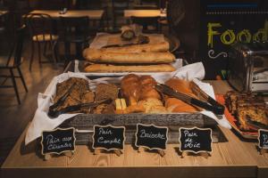 uma mesa com diferentes tipos de pão e pastelaria em HOTEL DES NEIGES em Les Deux Alpes