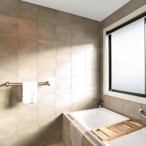 a bathroom with a bath tub and a window at TheRiverbend43 Wellington Marina in Wellington East