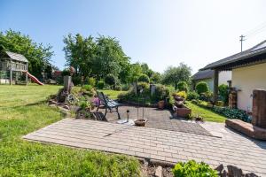 a backyard with a brick patio with a swing at Ferienwohnung Am Steinchen in Mettlach