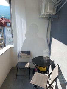 a table and chairs in a room with a window at Banesa ne qender te Pejes 2 in Peje