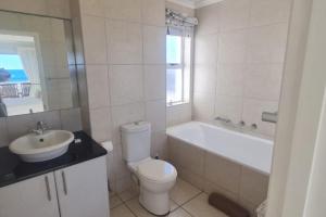 a bathroom with a toilet and a tub and a sink at Point Village Accommodation - Linda in Mossel Bay