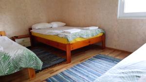 a small room with a bed and two rugs at Willipu peremajad in Pusi