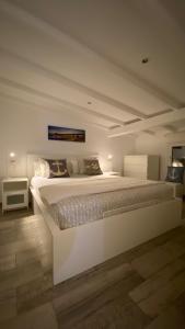 a white bedroom with a large white bed with pillows at Luxury oceanfront villa in an idyllic location no1 in Cala'n Bosch