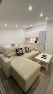 a white living room with a couch and a table at Luxury oceanfront villa in an idyllic location no1 in Cala'n Bosch