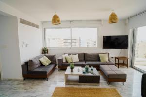 ein Wohnzimmer mit einem Sofa und einem Tisch in der Unterkunft Seaview Pearl Suite Larnaca in Larnaka