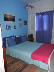 a bedroom with a large bed with blue walls at Meltemia Studio Samos No6 Pefkos in Votsalákia