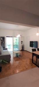 een woonkamer met een bank en een tafel bij Spacious 2bdr apartment @ Pagrati in Athene