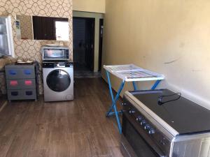 eine Küche mit einem Herd, einem Tisch und einer Waschmaschine in der Unterkunft Appartement Meublé à Louer 95m2 in Tiznit