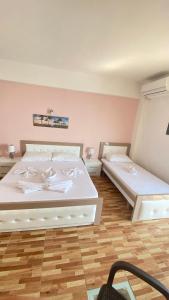 a bedroom with two beds and a wooden floor at Ria mare in Qeparo