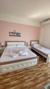 a bedroom with a large white bed with two bedsskirts at Ria mare in Qeparo