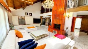 uma sala de estar com mobiliário branco e um lustre em Luxuriöse Villa Romantica em Gampel