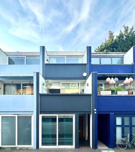 un edificio azul con ventanas y una bicicleta aparcada delante en 3 bdrm Notting Hill Mews house - 2 balconies en Londres