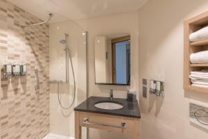 a bathroom with a sink and a shower at Hampton By Hilton Freiburg in Freiburg im Breisgau