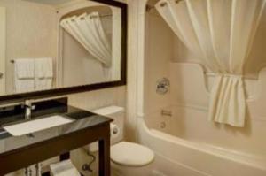 W łazience znajduje się umywalka, toaleta i lustro. w obiekcie Comfort Inn w mieście Orillia