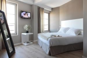a bedroom with a television and a bed at Rambla 102 in Barcelona