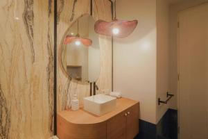 een badkamer met een wastafel en een spiegel bij Sonar Paraiso: A Dreamy Apartment in Jakarta in Madiun