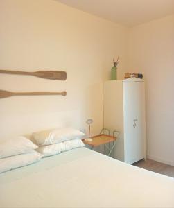 a bedroom with a white bed and a refrigerator at La Casina a Remi in Marone
