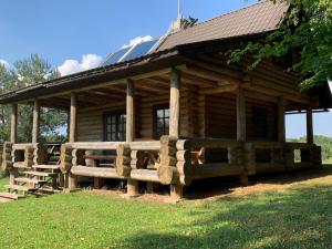 a log cabin with a bench in front of it at Poilsis ant Virintų ežero kranto in Molėtai