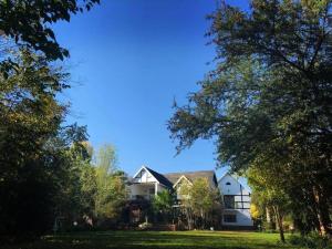 Aqua View Riverside Guesthouse في بارايس: منزل يجلس على فناء أخضر مع الأشجار