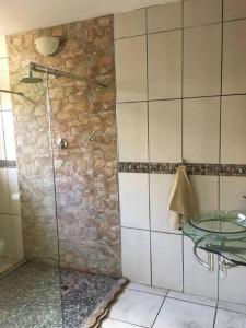 Aqua View Riverside Guesthouse في بارايس: حمام مع دش زجاجي بجدار حجري