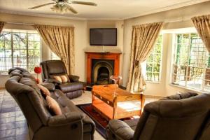 Aqua View Riverside Guesthouse في بارايس: غرفة معيشة مع كرسيين ومدفأة