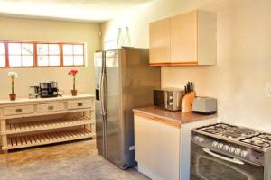 Aqua View Riverside Guesthouse في بارايس: مطبخ مع موقد وثلاجة