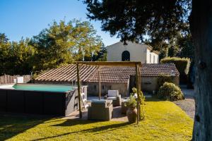 un patio trasero con piscina y una casa en CASENUOVE III - Casale con giardino e piscina en Castiglioncello