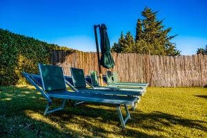una fila di sedie a sdraio blu con ombrellone di CASENUOVE III - Casale con giardino e piscina a Castiglioncello