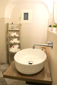 a bathroom with a sink and a shelf with towels at Suite dream room in Turi