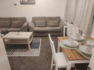 a living room with a couch and a table at Spacious Comfortable 4 Bedroom House in Aylesbury