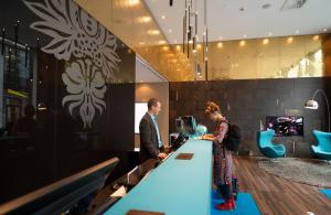 a man and a woman standing at a bar at Motel One Leipzig-Augustusplatz in Leipzig