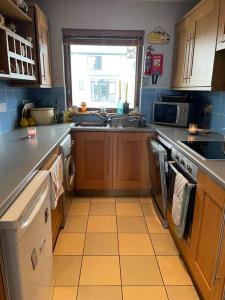 a kitchen with a sink and a stove top oven at Sea Breeze Cottage Mulranny in Mulranny