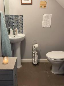 a bathroom with a white toilet and a sink at Sea Breeze Cottage Mulranny in Mulranny