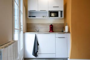 a kitchen with a sink and a microwave at Perpignan Monnaie - Appartement en centre ville in Perpignan