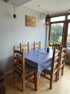 a dining room table with a blue table cloth on it at Sea Breeze Cottage Mulranny in Mulranny