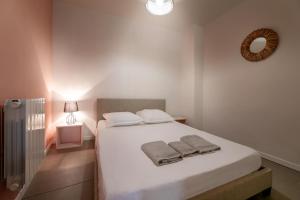 - une chambre avec un lit blanc et des serviettes dans l'établissement Perpignan - Appartement en centre ville, à Perpignan