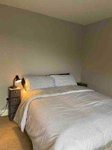 a bedroom with a bed and a lamp on a night stand at Sea Breeze Cottage Mulranny in Mulranny