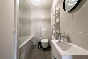 La salle de bains blanche est pourvue d'un lavabo et de toilettes. dans l'établissement Perpignan - Appartement en centre ville, à Perpignan