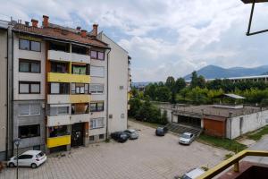 an apartment building with cars parked in a parking lot at BLOK apartment in Visoko