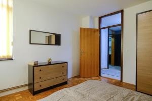 a bedroom with a dresser and a mirror on the wall at BLOK apartment in Visoko