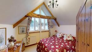 a bedroom with a bed and a large window at Otter Barn in Otterton