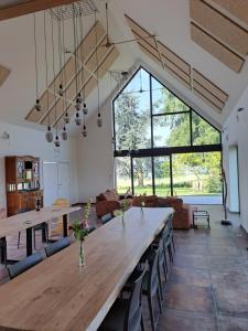 Habitación grande con mesa de madera grande y sillas. en Jubaru, en Tournai