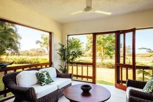 ein Wohnzimmer mit Stühlen, einem Tisch und Fenstern in der Unterkunft Sunny Vacation Villa No 98 in San Rafael del Yuma
