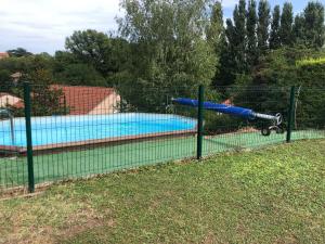 a fence in front of a swimming pool at Bienvenue in Le Cendre