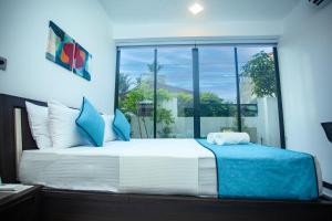 a bedroom with a large bed with a large window at The Five Residences in Galle