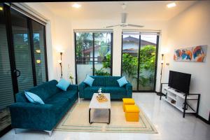 a living room with a blue couch and a tv at The Pearl Residences in Galle