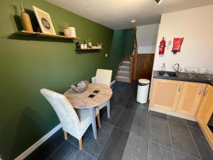 een keuken met een tafel en stoelen in een kamer bij Meadow View @ Glebe Barn in Pershore